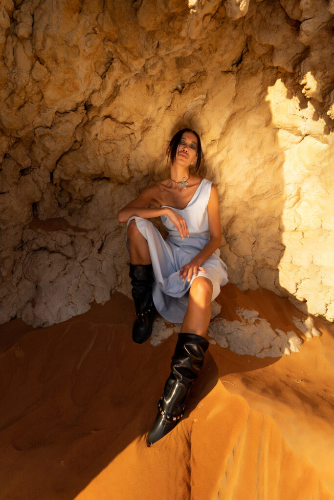 Model posing on a rocky outcrop in the desert