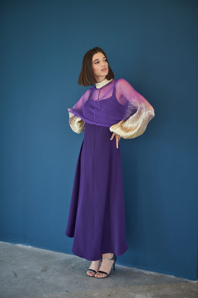 Fashion model in violet attire, blue background Designer Photoshoot