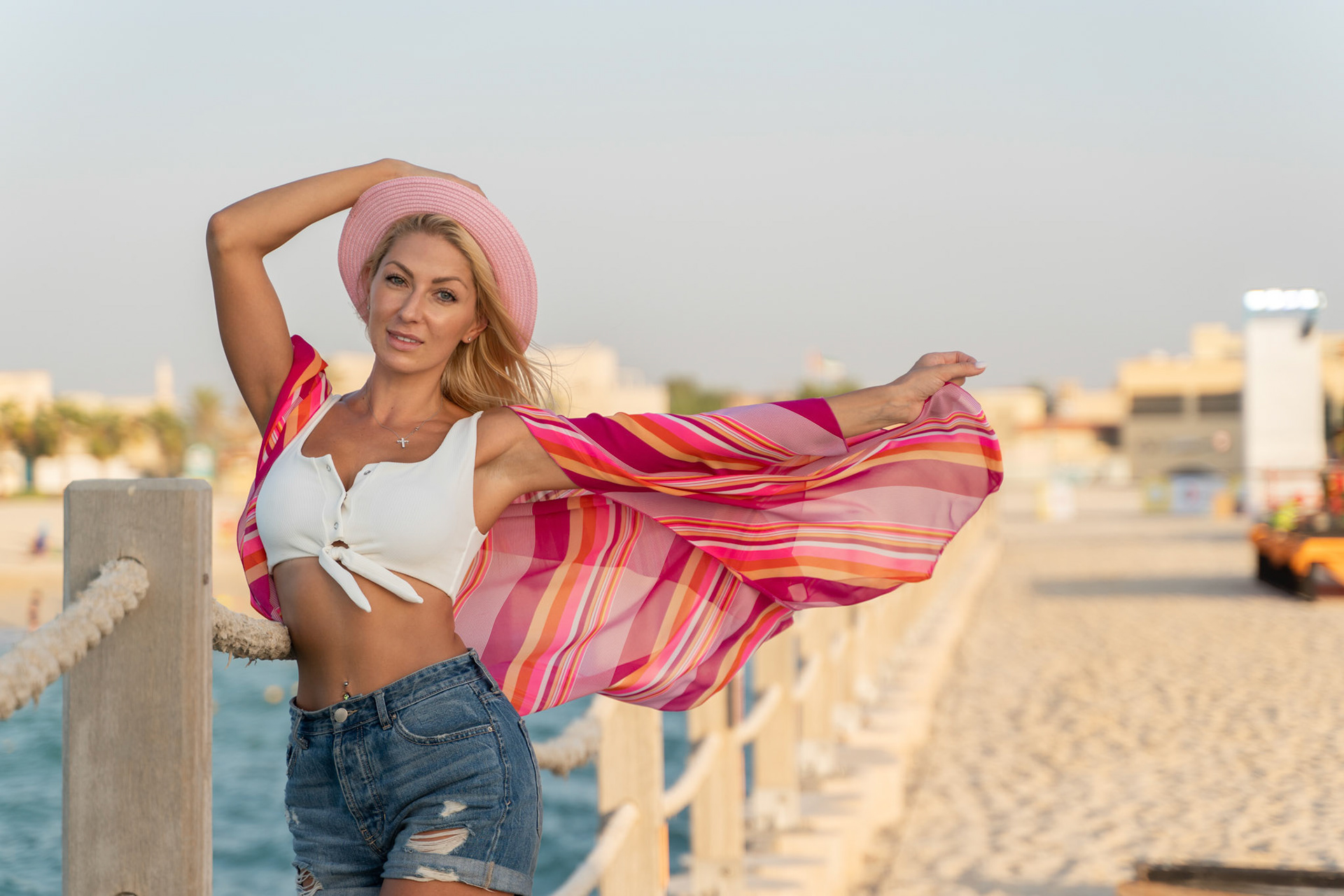 Woman in Hat and Denim Shorts on Dubai Beach by Ivan Cherkashin