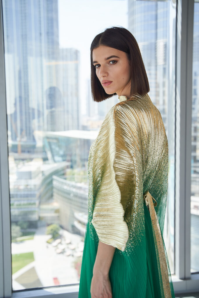 Model in green-gold abaya exuding confidence against Downtown Dubai