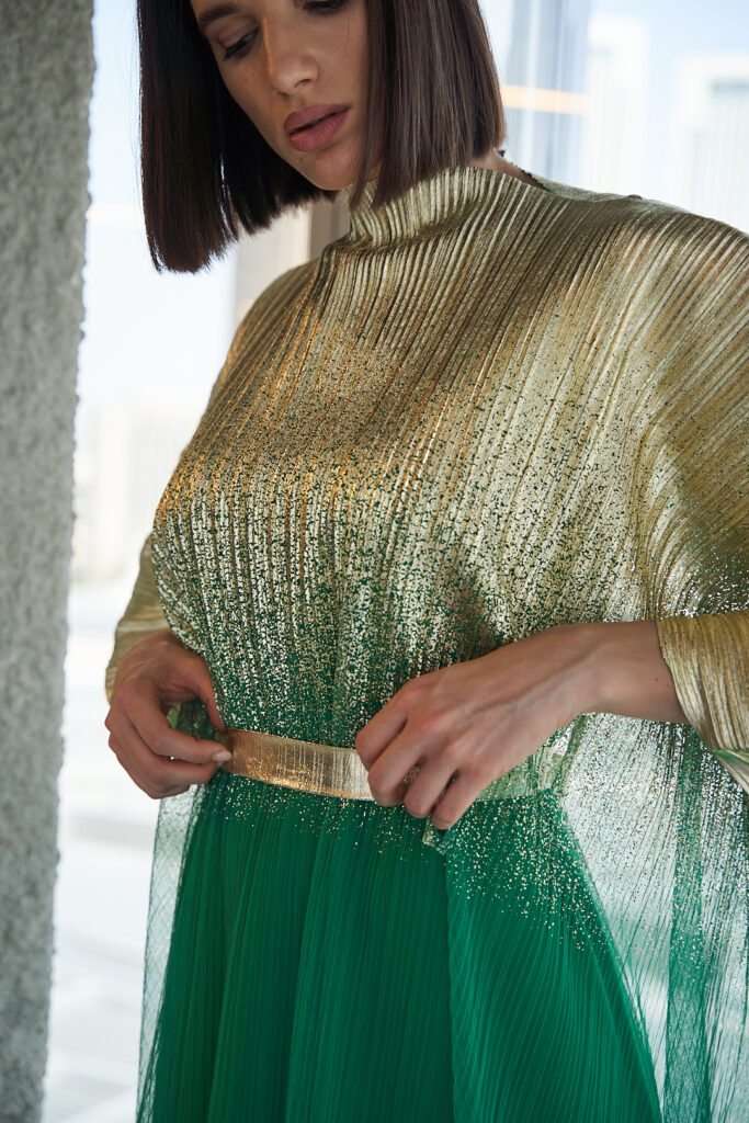 Model in green-gold abaya, heart of Dubai's fashion scene.